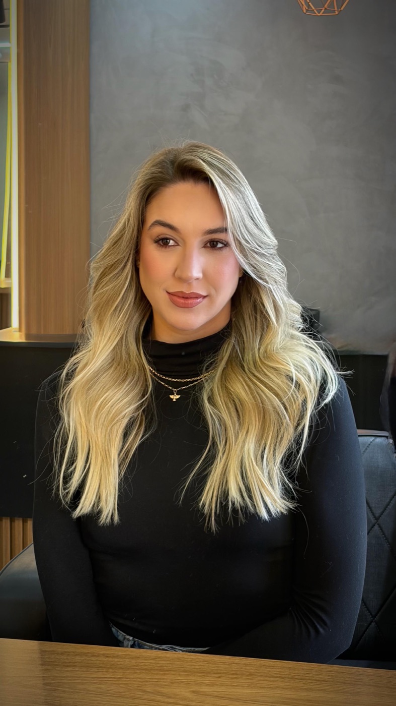 Cliente com cabelo loiro longo finalizado no salão